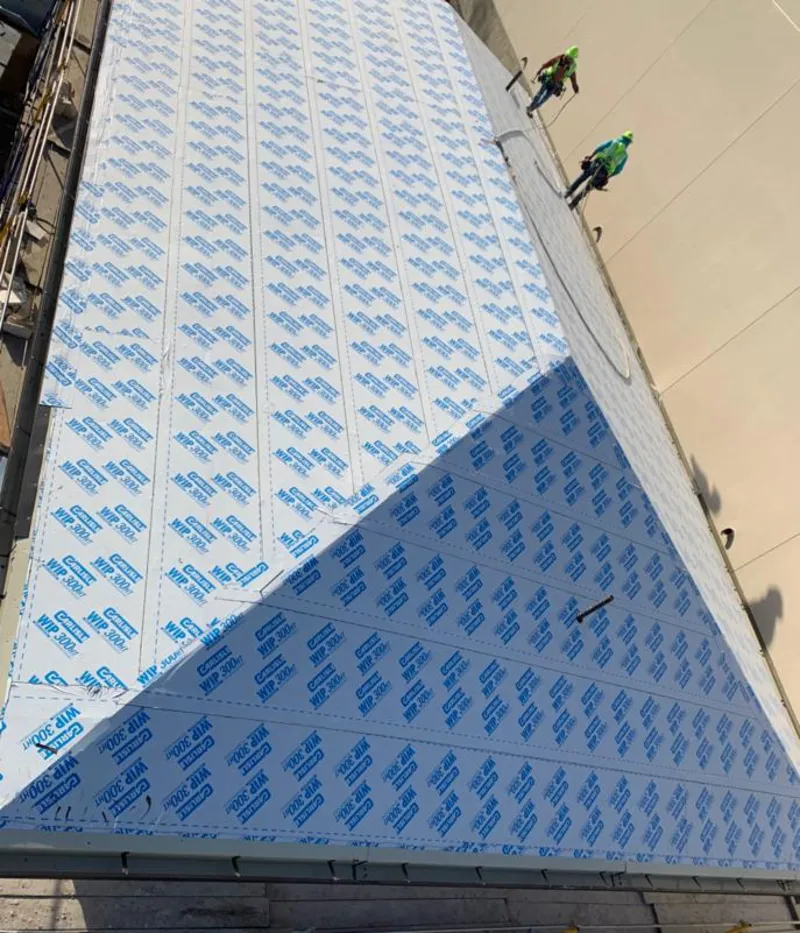 Professional roofers installing underlayment on a metal roof in Wilmington